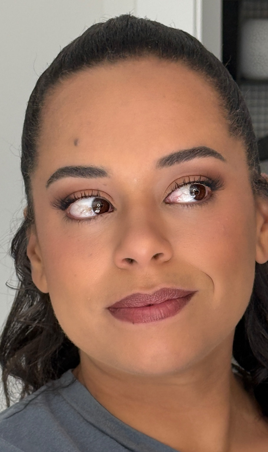 Warm bronze smoky eye with full lashes and a matte berry-mauve lip